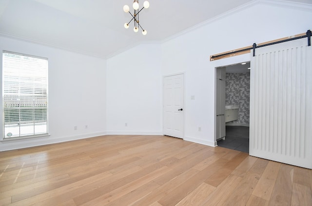 23210 Greenrush Dr, Katy, TX 77494 - empty room with a barn door, light wood finished floors, a chandelier, baseboards, and ornamental molding