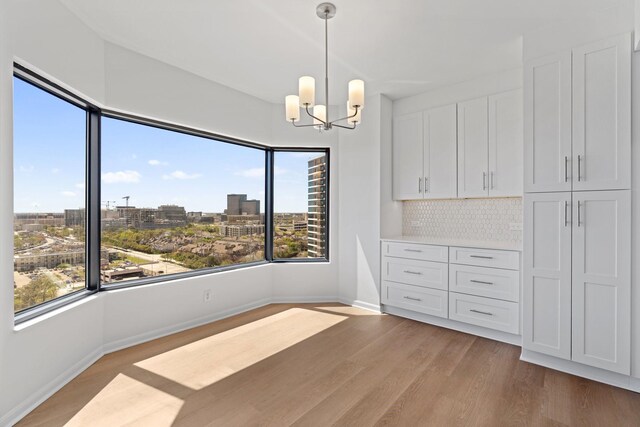 2001 Holcombe Blvd Unit 1605, Houston, TX 77030 - unfurnished dining area featuring a chandelier, light wood finished floors, baseboards, and a view of city