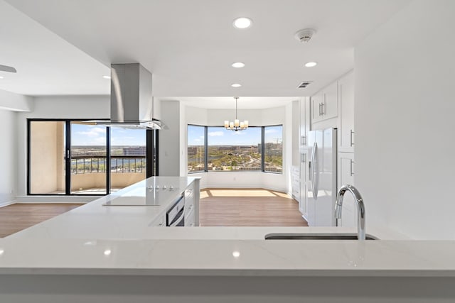 2001 Holcombe Blvd Unit 1605, Houston, TX 77030 - kitchen with white refrigerator with ice dispenser, electric cooktop, light wood-style flooring, recessed lighting, and a chandelier