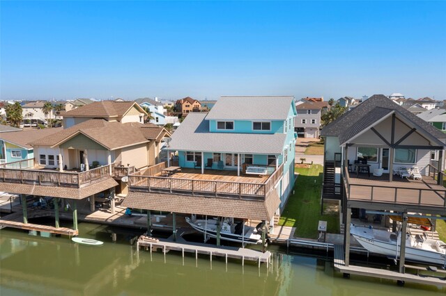 1815 Tiki Dr, Tiki Island, TX 77554 - rear view of property with boat lift, a residential view, and a water view