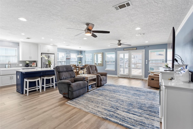 1815 Tiki Dr, Tiki Island, TX 77554 - living area with light wood-style flooring, ceiling fan, healthy amount of natural light, a textured ceiling, and recessed lighting