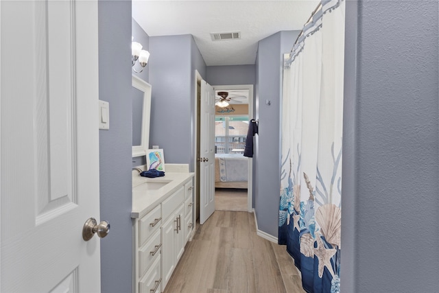 1815 Tiki Dr, Tiki Island, TX 77554 - full bath featuring wood finished floors, vanity, ceiling fan, ensuite bath, and baseboards