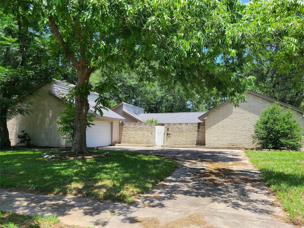 11514 Chetman Dr, Houston, TX 77065 - view of front of home with brick siding, concrete driveway, an attached garage, and a front lawn