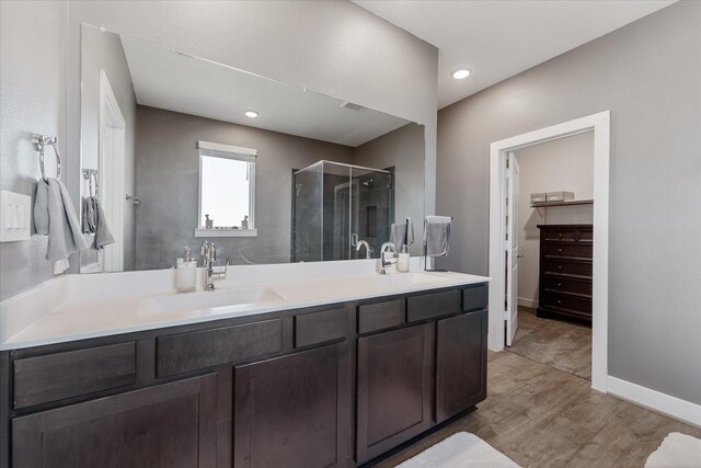 770 Dogberry Ct, Conroe, TX 77304 - full bathroom with a shower stall, wood finished floors, double vanity, a walk in closet, and recessed lighting