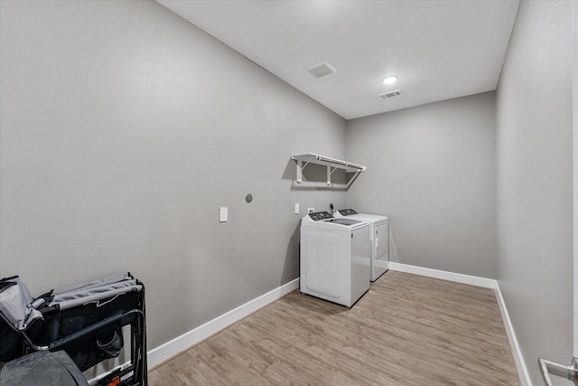770 Dogberry Ct, Conroe, TX 77304 - laundry area featuring washer and clothes dryer, baseboards, and light wood-style flooring