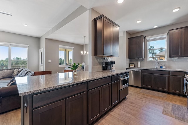 770 Dogberry Ct, Conroe, TX 77304 - kitchen with stainless steel dishwasher, a sink, open floor plan, plenty of natural light, and recessed lighting