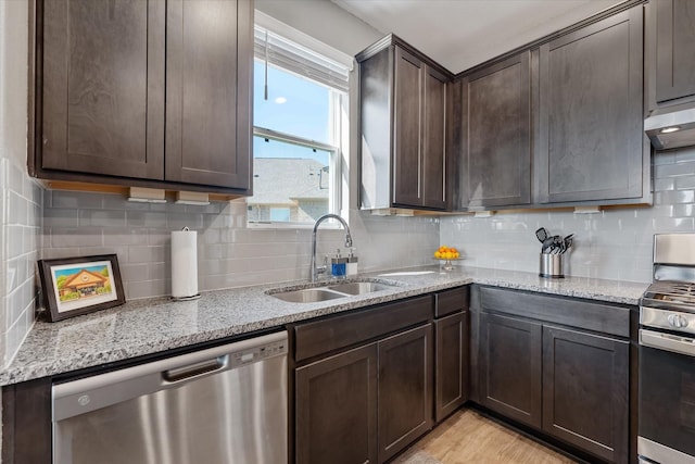 770 Dogberry Ct, Conroe, TX 77304 - kitchen with appliances with stainless steel finishes, a sink, dark brown cabinetry, and decorative backsplash