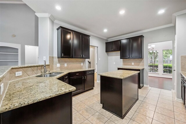 13614 Heath Spring Ct, Houston, TX 77044 - kitchen with a sink, light stone counters, crown molding, decorative backsplash, and light tile patterned floors
