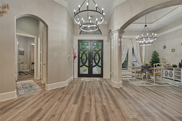 15471 Castlebrook Ct, Montgomery, TX 77316 - foyer entrance with arched walkways, ornamental molding, a chandelier, wood finished floors, and french doors