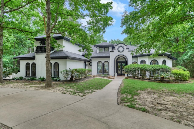 15471 Castlebrook Ct, Montgomery, TX 77316 - french provincial home with french doors, stucco siding, a balcony, a shingled roof, and a front yard