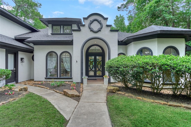 15471 Castlebrook Ct, Montgomery, TX 77316 - view of exterior entry with roof with shingles, french doors, stucco siding, and a yard