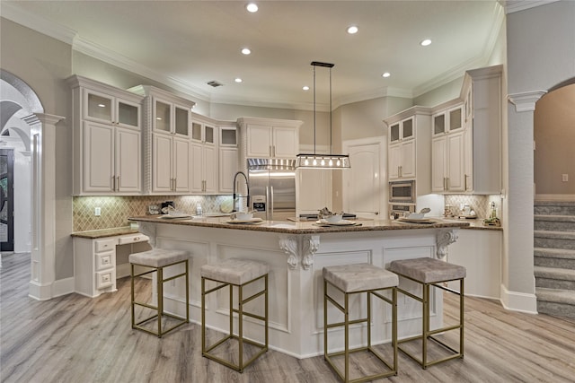 15471 Castlebrook Ct, Montgomery, TX 77316 - kitchen with ornate columns, built in appliances, arched walkways, a spacious island, and recessed lighting