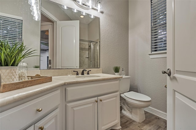 15471 Castlebrook Ct, Montgomery, TX 77316 - full bath featuring a textured wall, wood finished floors, toilet, tiled shower, and vanity