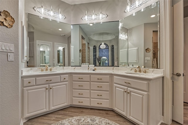 15471 Castlebrook Ct, Montgomery, TX 77316 - bathroom with wood finished floors, double vanity, recessed lighting, and a textured wall