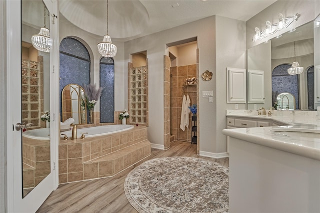 15471 Castlebrook Ct, Montgomery, TX 77316 - full bath featuring wood finished floors, a bath, a tile shower, vanity, and a chandelier