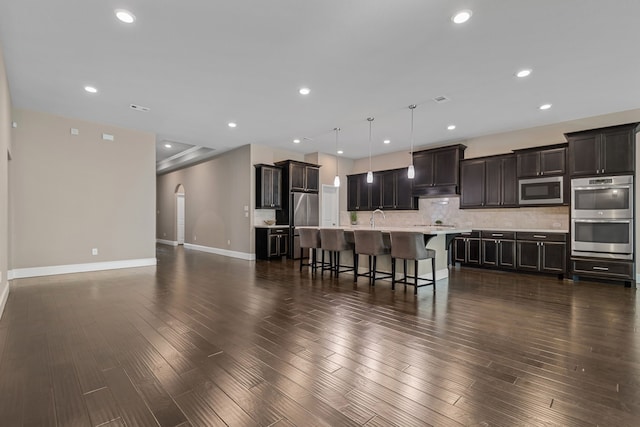 2037 Capriccio Dr, Spring, TX 77386 - kitchen featuring stainless steel appliances, light countertops, a kitchen breakfast bar, decorative backsplash, and a kitchen island with sink