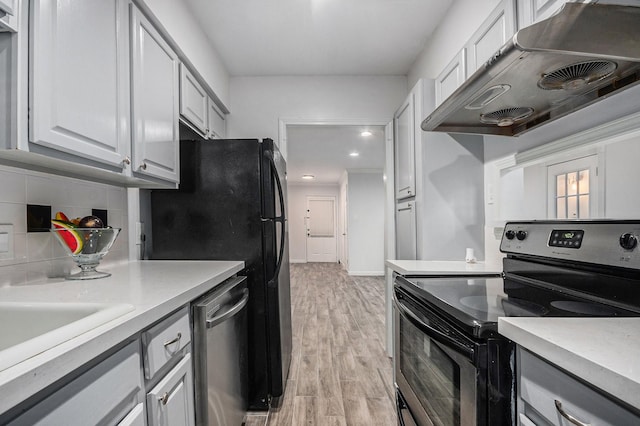 8245 Kingsbrook Rd Unit 139, Houston, TX 77024 - kitchen featuring appliances with stainless steel finishes, under cabinet range hood, light wood-style flooring, light countertops, and recessed lighting