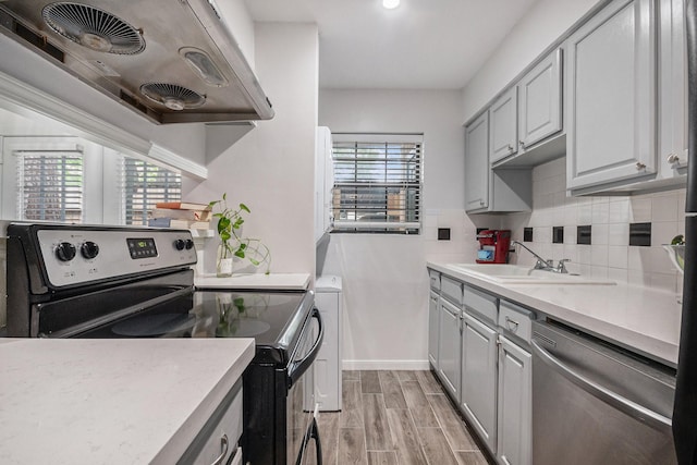 8245 Kingsbrook Rd Unit 139, Houston, TX 77024 - kitchen with stainless steel appliances, extractor fan, a sink, gray cabinets, and light countertops