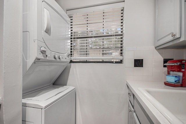 8245 Kingsbrook Rd Unit 139, Houston, TX 77024 - laundry area featuring stacked washing machine and dryer and cabinet space