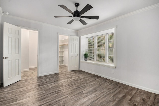 8245 Kingsbrook Rd Unit 139, Houston, TX 77024 - unfurnished bedroom featuring wood finished floors, baseboards, crown molding, a walk in closet, and a closet