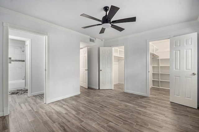 8245 Kingsbrook Rd Unit 139, Houston, TX 77024 - unfurnished bedroom with a walk in closet, wood finished floors, baseboards, crown molding, and ensuite bathroom