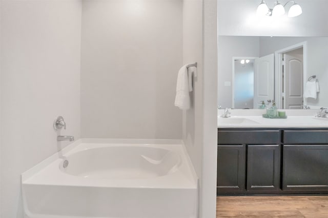 11355 Dawn Beach Ln, Conroe, TX 77304 - bathroom with a bath, double vanity, and wood finished floors