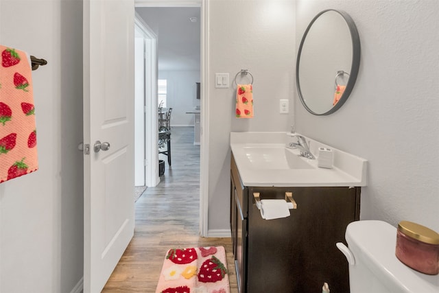 11355 Dawn Beach Ln, Conroe, TX 77304 - bathroom with vanity, wood finished floors, baseboards, and toilet