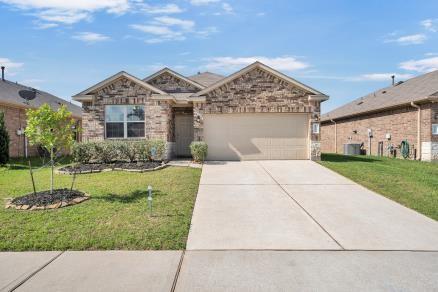 11355 Dawn Beach Ln, Conroe, TX 77304 - view of front of home featuring an attached garage, driveway, and a front lawn