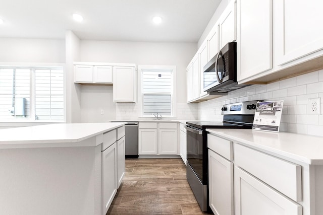 16912 Kempwood, Montgomery, TX 77316 - kitchen with appliances with stainless steel finishes, light wood finished floors, white cabinets, tasteful backsplash, and recessed lighting