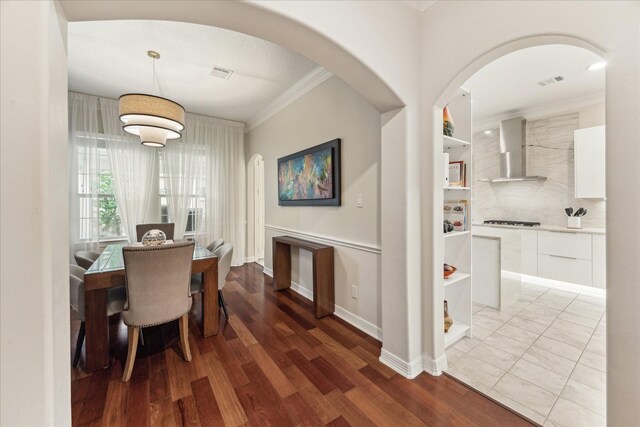 14402 Basalt Ln, Houston, TX 77077 - dining space with crown molding, arched walkways, wood finished floors, and baseboards