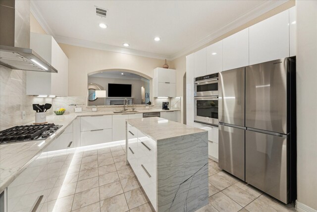 14402 Basalt Ln, Houston, TX 77077 - kitchen featuring wall chimney range hood, stainless steel appliances, modern cabinets, ornamental molding, and a kitchen island