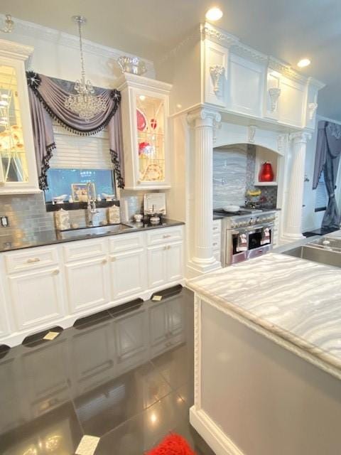 kitchen featuring a sink, high end range, decorative backsplash, a chandelier, and recessed lighting