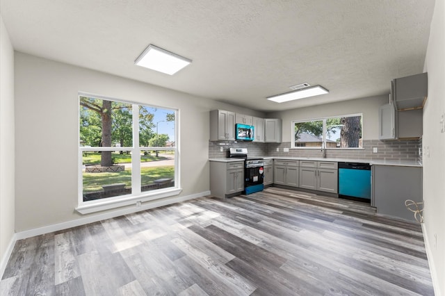 4434 Falcon Meadow Dr, Katy, TX 77449 - kitchen featuring appliances with stainless steel finishes, gray cabinets, backsplash, light countertops, and wood finished floors