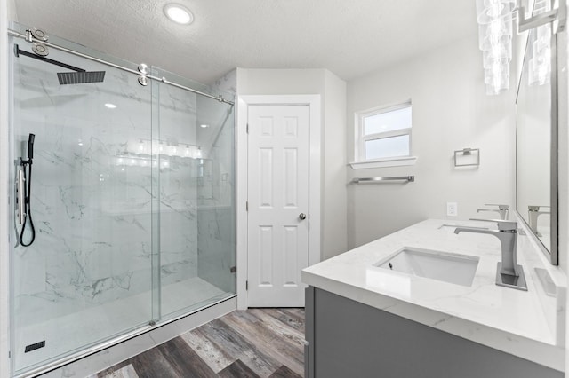 4434 Falcon Meadow Dr, Katy, TX 77449 - full bathroom with wood finished floors, a marble finish shower, a textured ceiling, double vanity, and recessed lighting
