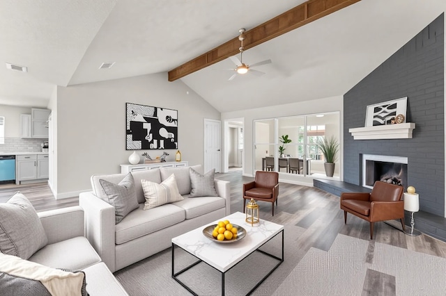 4434 Falcon Meadow Dr, Katy, TX 77449 - living room featuring light wood finished floors, ceiling fan, beam ceiling, a fireplace, and high vaulted ceiling