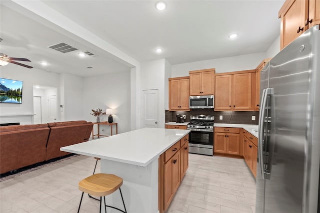 21106 Garden Palm Dr, Cypress, TX 77433 - kitchen with stainless steel appliances, open floor plan, light countertops, decorative backsplash, and ceiling fan