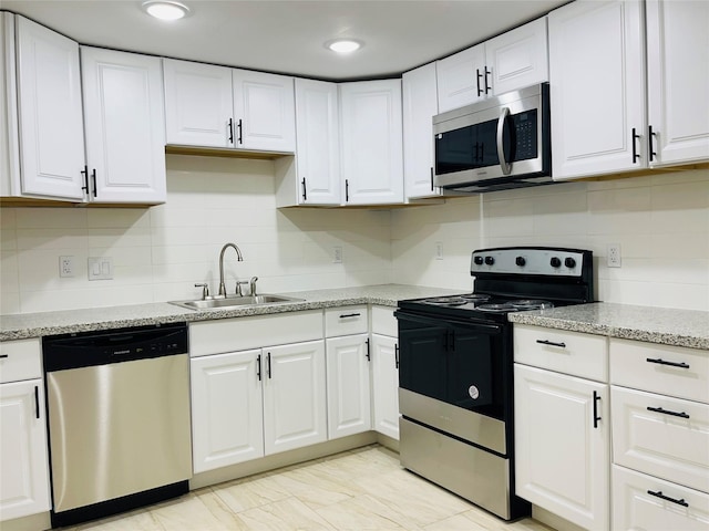 506 N Hackberry St, Sweeny, TX 77480 - kitchen with appliances with stainless steel finishes, a sink, white cabinetry, backsplash, and light stone countertops
