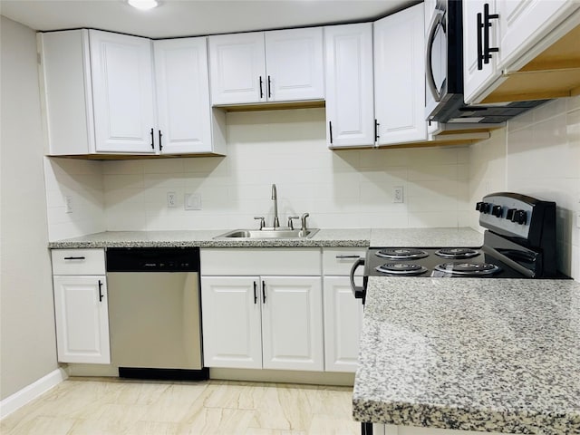 506 N Hackberry St, Sweeny, TX 77480 - kitchen featuring stainless steel appliances, a sink, white cabinets, tasteful backsplash, and baseboards