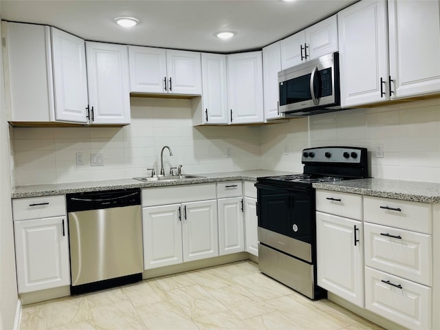 506 N Hackberry St, Sweeny, TX 77480 - kitchen featuring appliances with stainless steel finishes, a sink, white cabinetry, and tasteful backsplash