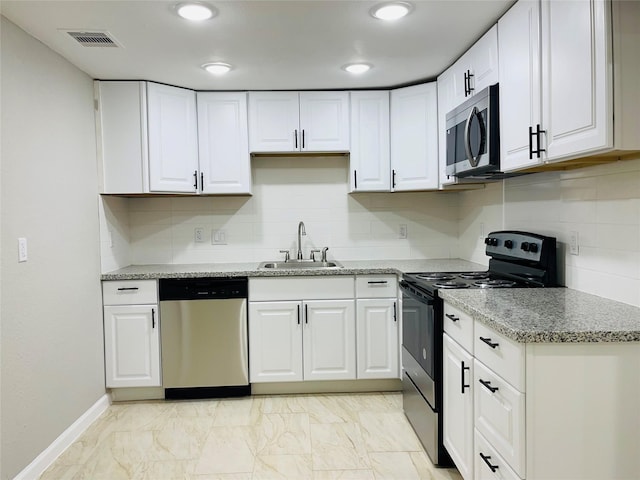 506 N Hackberry St, Sweeny, TX 77480 - kitchen featuring appliances with stainless steel finishes, a sink, white cabinetry, baseboards, and tasteful backsplash