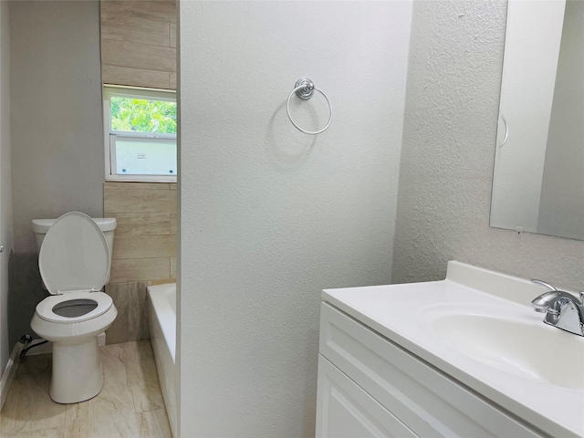 506 N Hackberry St, Sweeny, TX 77480 - bathroom with vanity, toilet, a bath, marble look tile flooring, and a textured wall