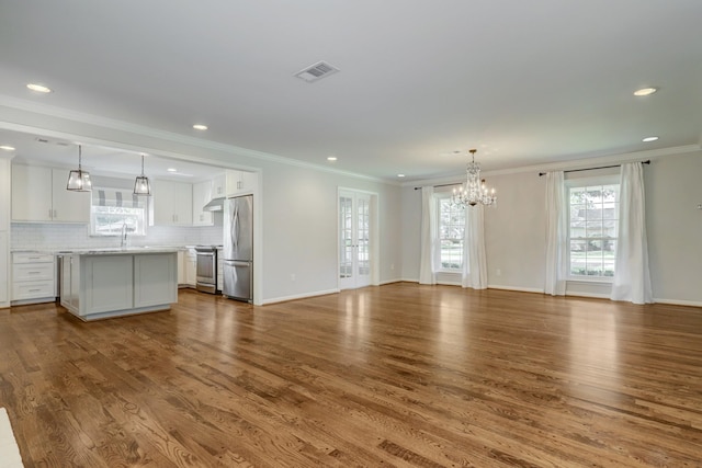 5215 Stillbrooke Dr, Houston, TX 77035 - unfurnished living room featuring a chandelier, dark wood-type flooring, recessed lighting, crown molding, and a sink