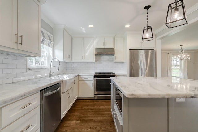 5215 Stillbrooke Dr, Houston, TX 77035 - kitchen featuring stainless steel appliances, a sink, under cabinet range hood, crown molding, and dark wood-type flooring
