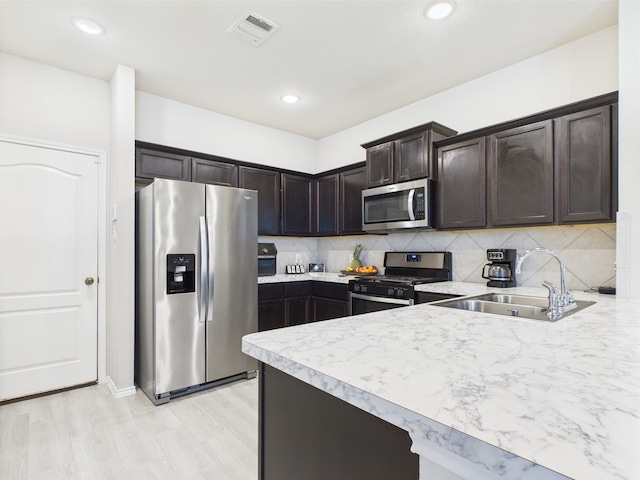 12671 Taymouth Manor Dr Unit 6, Humble, TX 77346 - kitchen featuring appliances with stainless steel finishes, a sink, light countertops, dark brown cabinetry, and tasteful backsplash