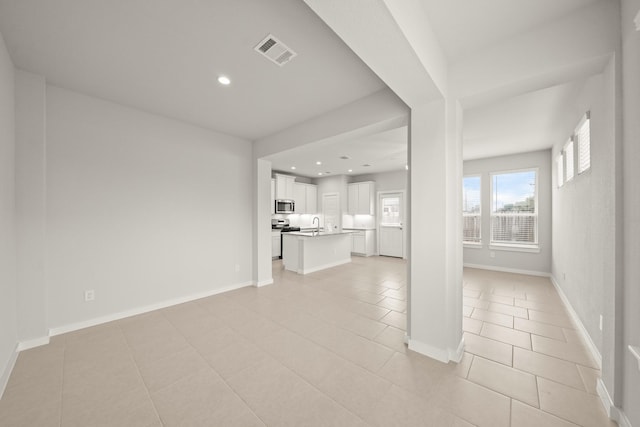 2906 Park Hill Ln, Stafford, TX 77477 - unfurnished living room featuring light tile patterned floors, recessed lighting, baseboards, and a sink