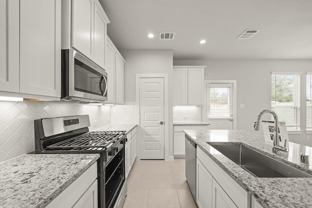 2906 Park Hill Ln, Stafford, TX 77477 - kitchen with appliances with stainless steel finishes, a sink, tasteful backsplash, white cabinetry, and recessed lighting