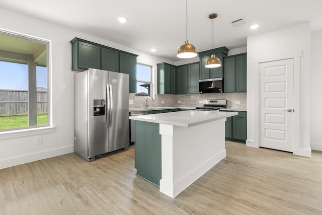 kitchen with stainless steel appliances, green cabinets, decorative backsplash, light wood-style floors, and recessed lighting