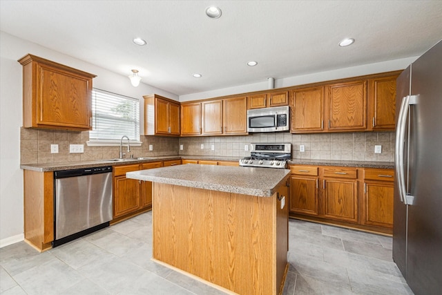 1056 Inverness Cv, Dickinson, TX 77539 - kitchen with appliances with stainless steel finishes, a sink, brown cabinets, a kitchen island, and tasteful backsplash