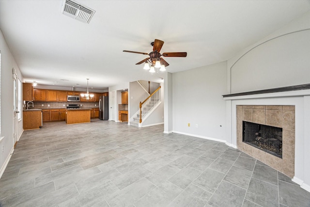 1056 Inverness Cv, Dickinson, TX 77539 - unfurnished living room featuring stairway, a fireplace, a ceiling fan, baseboards, and a sink