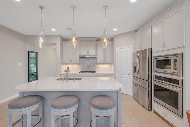 6323 Grand Summit Ct, Katy, TX 77494 - kitchen featuring stainless steel appliances, a sink, tasteful backsplash, light countertops, and a breakfast bar